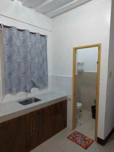a bathroom with a sink and a toilet and a window at RedDoorz at Wyns Hotel in Silañgang Mayao