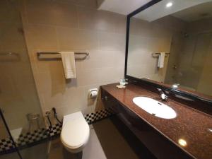 a bathroom with a sink and a toilet and a mirror at Parkview Hotel in Kampong Jerudong