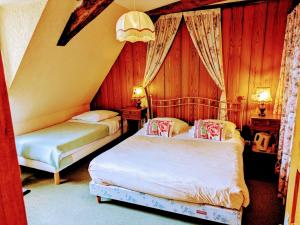 a bedroom with two beds and two tables and two lamps at Domaine de Launay blot in Baguer-Morvan