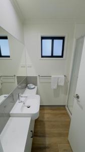 a white bathroom with a sink and a mirror at Griffith Tourist Caravan Park in Griffith