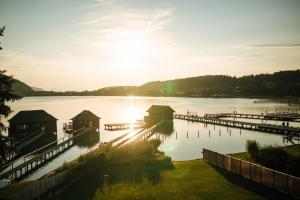 a dock on a lake with the sun setting at Seensucht Klopeinersee in Sankt Kanzian