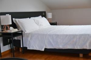 a bedroom with a white bed with a black headboard at Cannubi San Lorenzo Appartamento in Barolo