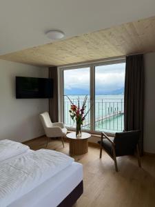a hotel room with a bed and a large window at Seehotel Lilly in Strobl +130 photos