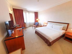 a hotel room with a bed and a television at Parkview Hotel in Kampong Jerudong