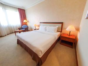 a hotel room with a large bed and a window at Parkview Hotel in Kampong Jerudong