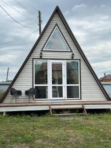 a house with two chairs sitting on a porch at Афреем дом in Borovoye