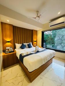 a bedroom with a large bed and a large window at Hotel Comfort Castle in Mumbai