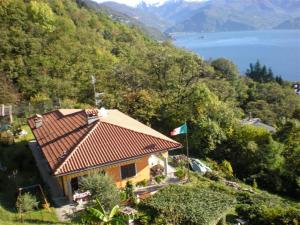 Una casa en una colina con una bandera. en Casa Gardenia, en Oggebbio