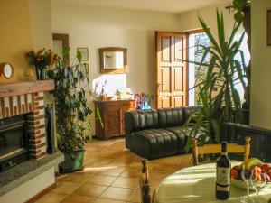 sala de estar con sofá y mesa con botellas de vino en Casa Gardenia, en Oggebbio