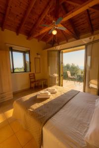 a bedroom with a bed with a ceiling fan at Amoni Holiday Homes in Kardamili