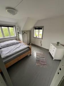 1 dormitorio con 1 cama, 2 ventanas y alfombra en Haus Harald, en Tysnes