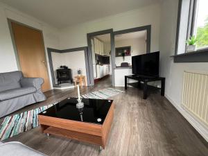 Una sala de estar con un sofá y un televisor. en Haus Harald, en Tysnes
