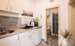 a kitchen with a sink and a microwave at Armoni Safit Mandala - Romantic City Apartment near Flexum Thermal Spa in Mosonmagyaróvár +23 photos