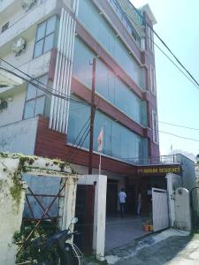 una motocicleta estacionada frente a un edificio en Mayank Residency, en Dehradun