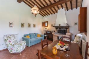 a living room with a table and a blue couch at LA COLLINA DEGLI ULIVI 8&2, Emma Villas in Montefalco