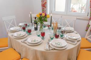 a table with plates and glasses and flowers on it at LA COLLINA DEGLI ULIVI 8&2, Emma Villas in Montefalco