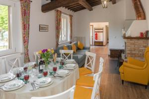 a dining room with a table and a living room at LA COLLINA DEGLI ULIVI 8&2, Emma Villas in Montefalco +49 photos