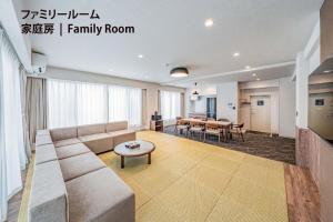 a living room with a couch and a table at Apartment Hotel 11 Nippombashi in Osaka