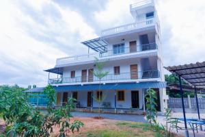 a large white building with balconies and trees at Auro Ocean View Residency in Pondicherry +11 photos