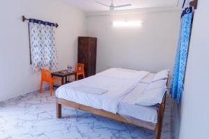 a bedroom with a bed and a table and chairs at Auro Ocean View Residency in Pondicherry