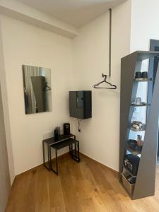 a room with a table and a tv on a wall at Nõs Luxury Rooms in Mesolongion