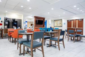 a dining room with tables and chairs in a cafeteria at Holiday Inn Express Hotel & Suites Memphis/Germantown by IHG in Memphis