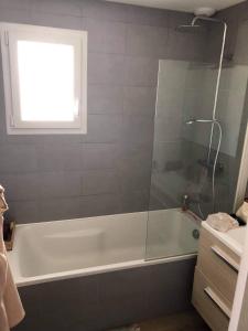 a bathroom with a shower and a tub with a window at Chambre paisible proche Centre Ville in Saint-Yrieix-sur-Charente