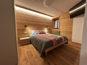 a bedroom with a bed in a wooden wall at Affittacamere Tarvisio in Tarvisio