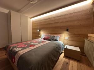 a bedroom with a bed with a wooden wall at Affittacamere Tarvisio in Tarvisio
