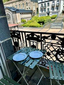 een tafel op een balkon met borden erop bij Val-locations thermes 5 in Le Mont-Dore