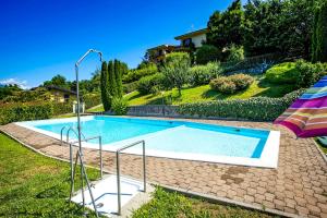 a swimming pool in a yard with an umbrella at Residenz Moncucco in Luino