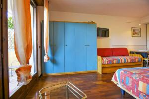 a bedroom with a blue cabinet and a couch at Residenz Moncucco in Luino