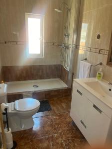 a bathroom with a toilet and a shower and a sink at Paloma Caparica Beach in Costa da Caparica