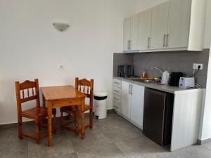 a kitchen with a table and chairs and a sink at Paleo Apartments in Paleokastritsa