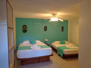 2 camas en una habitación con paredes verdes en Hotel Casa del Mar, en Sámara