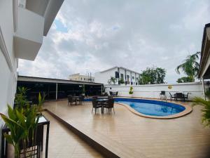 a balcony with a pool and tables and chairs at Presken Hotel White House, Lekki, Lagos in Lagos
