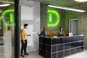 three people standing at a counter in an office at Domeq in Komárov