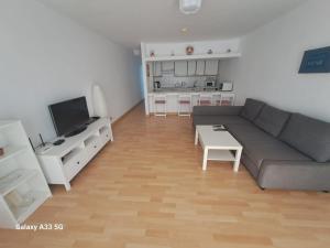 salon z szarą kanapą i kuchnią w obiekcie Bonito apartamento reformado en Las Coronas w Costa Teguise