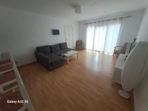 salon z kanapą i stołem w obiekcie Bonito apartamento reformado en Las Coronas w Costa Teguise