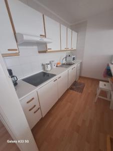 kuchnia z białymi szafkami i zlewem w obiekcie Bonito apartamento reformado en Las Coronas w Costa Teguise