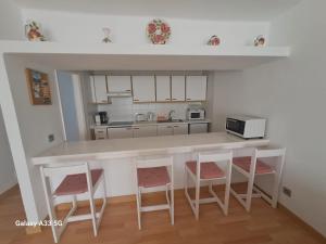 kuchnia z blatem i czterema stołkami w obiekcie Bonito apartamento reformado en Las Coronas w Costa Teguise