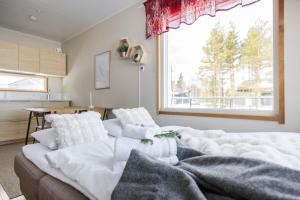 a living room with a couch and a large window at Arctic Snow Lake Mini Lodge in Rovaniemi