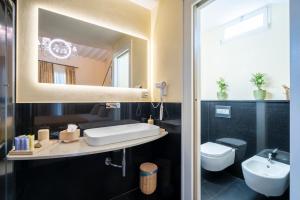 a bathroom with a sink and a toilet and a mirror at Duomo Suites Florence in Florence
