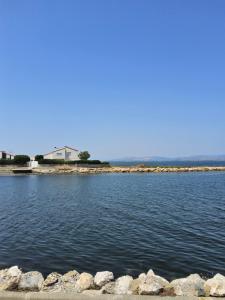 RARE maison du pêcheur en première ligne avec clim في لو باركار: a large body of water with a house in the background