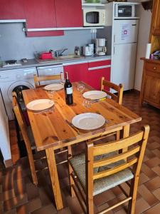 RARE maison du pêcheur en première ligne avec clim في لو باركار: طاولة خشبية في مطبخ مع زجاجة من النبيذ