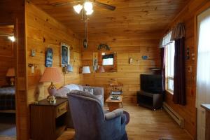 ein Wohnzimmer mit Sofa, Schreibtisch und Fernseher in der Unterkunft Meadowview Cottages in North Milton