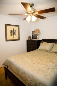 a bedroom with a ceiling fan and a bed at Serenity in Burnaby