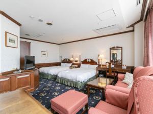 Una habitación de hotel con dos camas y un televisor. en Victoria Inn Nagasaki, en Nagasaki