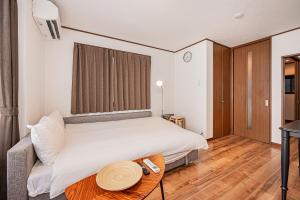 a bedroom with a white bed and a table at Tokyo Stay House Hirai in Tokyo