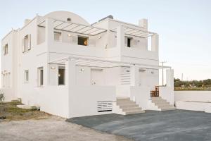 a white house with stairs in front of it at Santorini's Old Mill Serene Getaway by Pori Beach in Vourvoulos